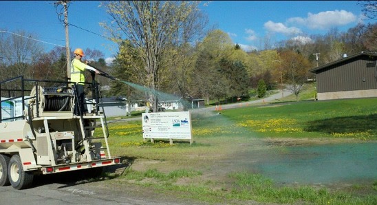 Hydroseeding rig spraying green slurry over graded ground