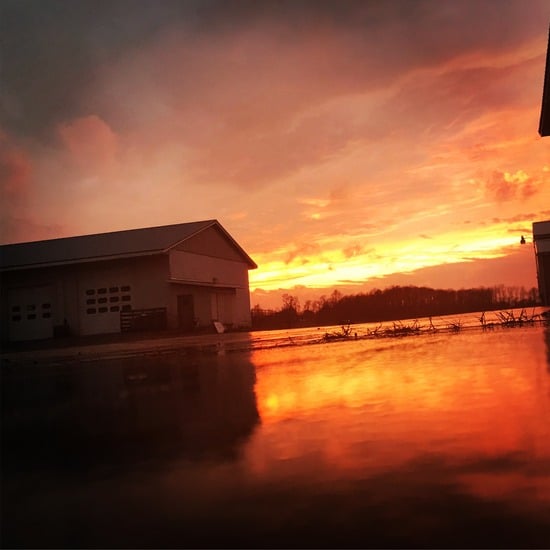 Pilon's shop building at sunset with standing water across the yard reflecting the sky